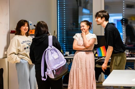 ISL students chatting with one of them holding a LGBTQIA+ flag